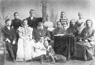 Отец Василий Конюхов (в центре) с семьей. В первом ряду крайний справа сидит отец Михаил, рядом с ним стоит Агния Васильевна. Справа у ног деда сидит маленький Николай Накаряков. <br> Ист.: <i>Бояршинов В. Г.</i> Летопись православных храмов Мотовилихи. С. 142