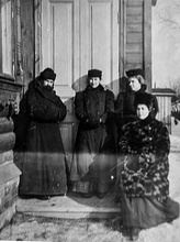 Александр Сергеевич Парусников с супругой. Рядом подруги Александры Ивановны, сельские учительницы. У дверей дома Парусниковых, зима, 1910.  Ист.: pravmir.ru
